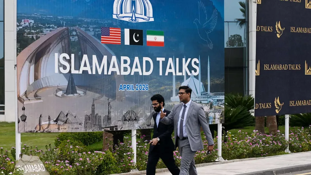 Personas pasan frente al centro de prensa para las conversaciones entre Estados Unidos e Irán en Islamabad, Pakistán, el 11 de abril de 2026. Se espera que Estados Unidos e Irán celebren una negociación en Islamabad para poner fin a las recientes hostilidades en Medio Oriente. (Xinhua/Wang Shen)