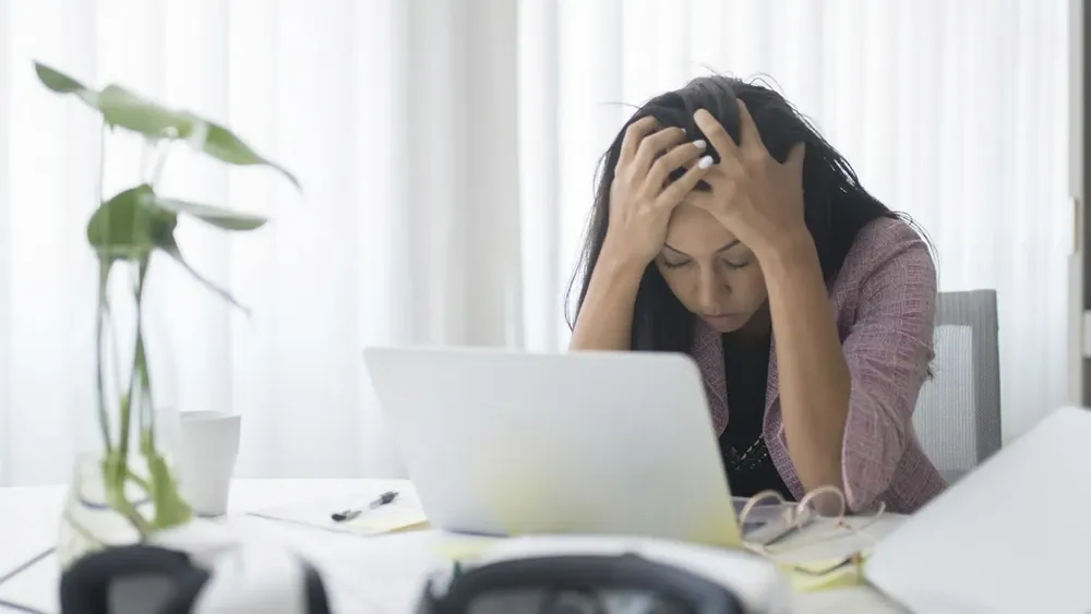 Foto referencial Ley Karin. Mujer estresada.