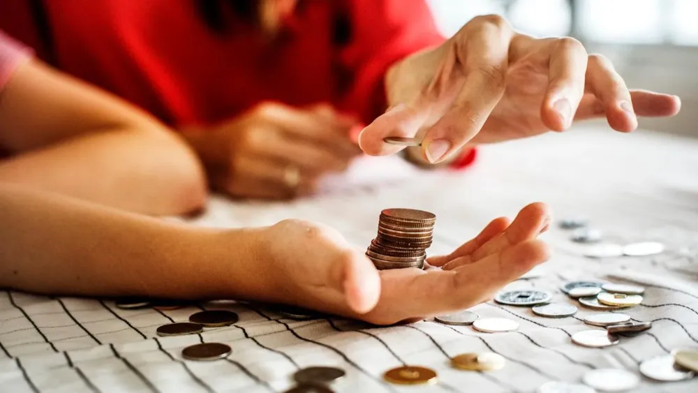 Personas contando monedas. Sobreendeudamiento.