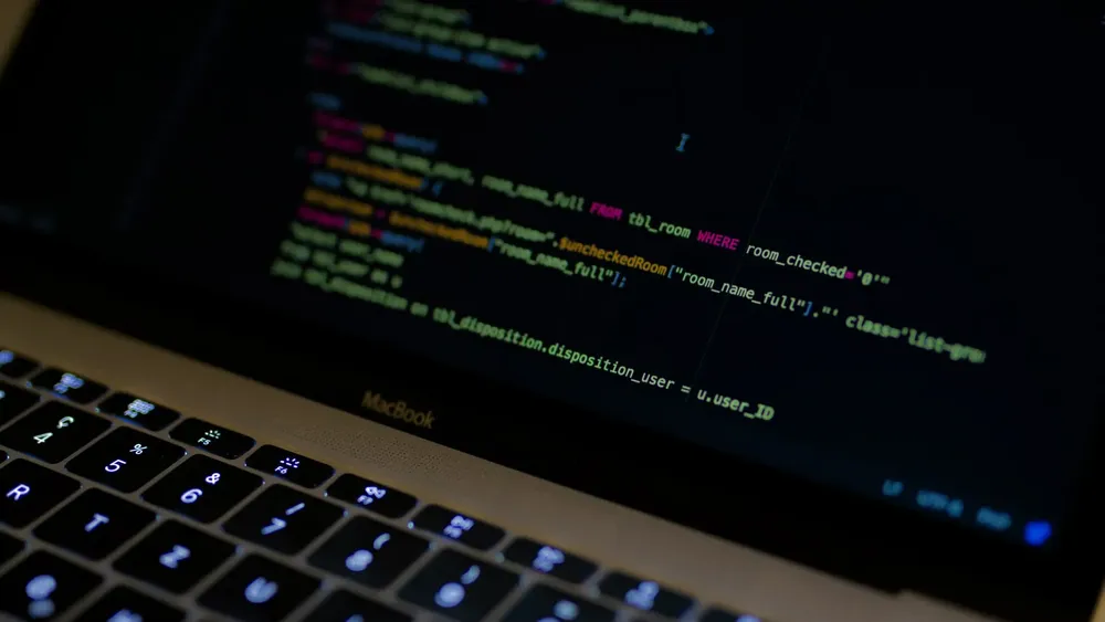 Computador con código en pantalla. Créditos: Pexels.